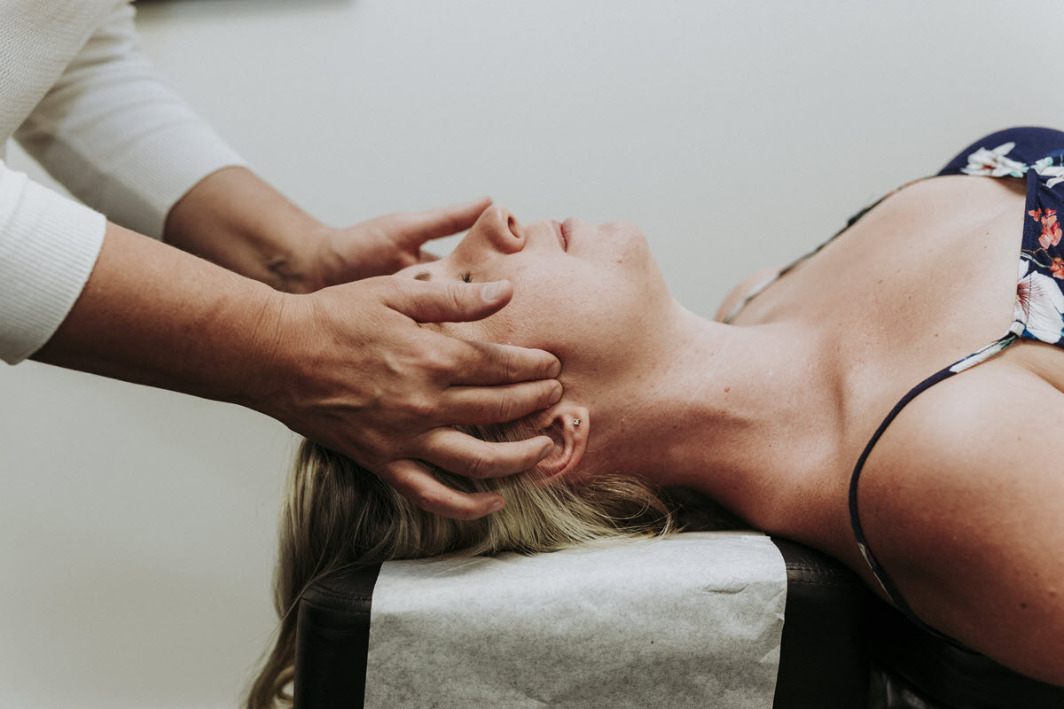 Specialised chiropractor applying pressure to womans head.