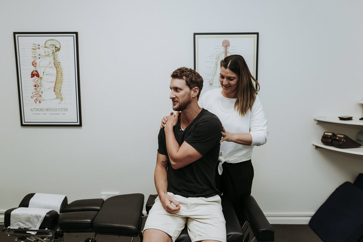 Chiropractor working with a man suffering from shoulder pain.